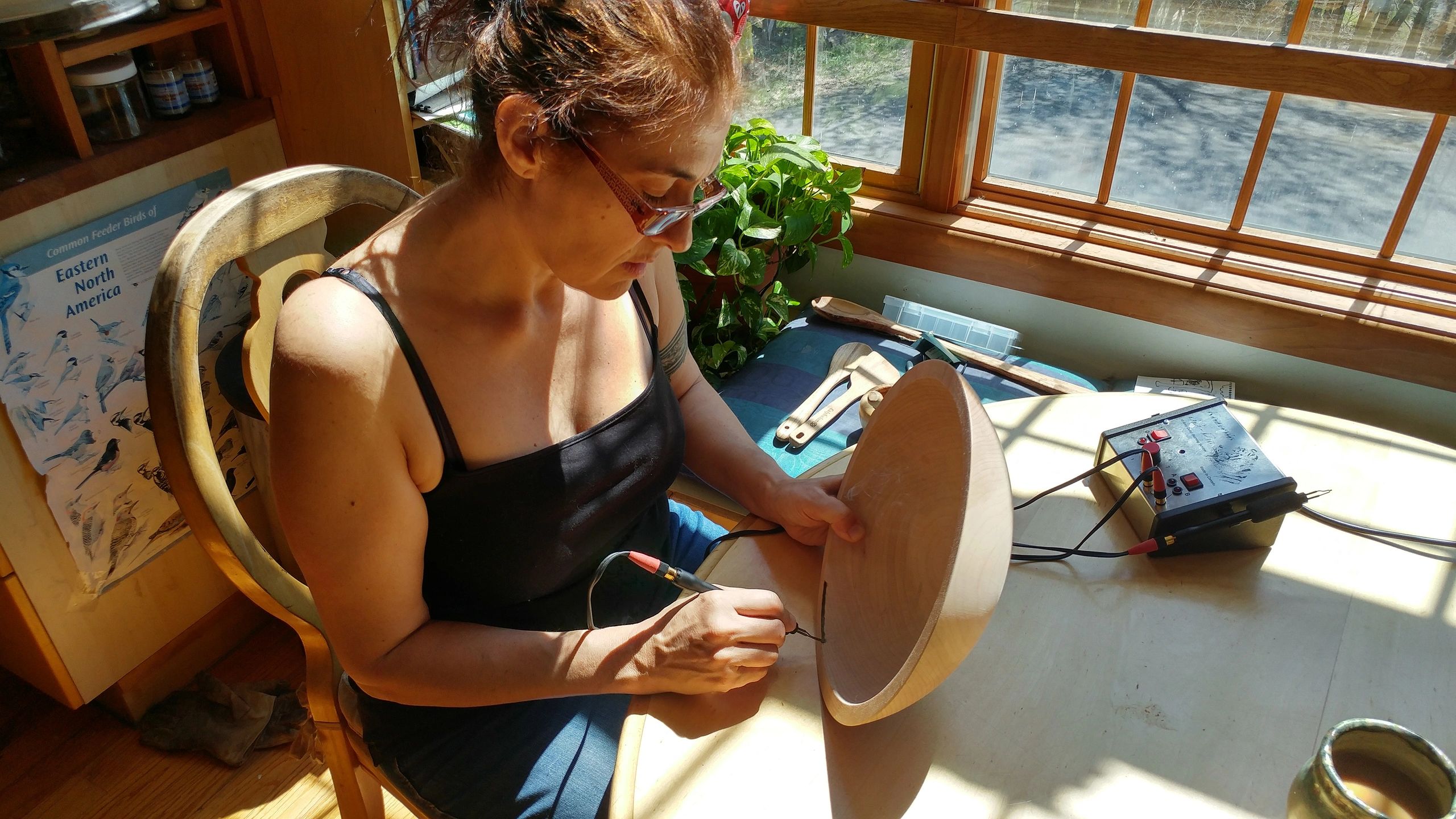 Artist working at wooden table with tools